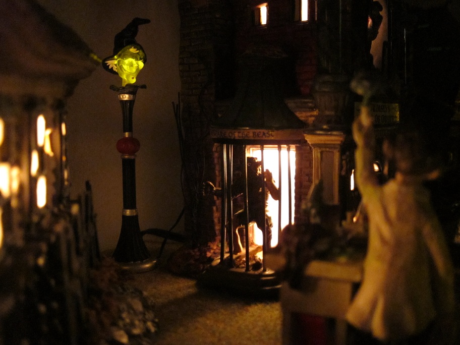 Zoomed in shot of the witch lightpost(there's a second one) and the werewolf behind bars at the House of Oddities