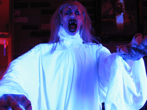 This is my new glowing vampire.  She was a severed head I bought on sale after Halloween last year, but I have plenty of heads hanging, so I made her a porch-creature.  I outfitted her in robes I stitched out of cotton fabric I got for seven bucks (ten yards), and put her under a 48&quot; blacklight I bought at Spirit last year during the after Halloween sale.  Under her robes, she's a pvc frame attached to a weighted wood base I built.
